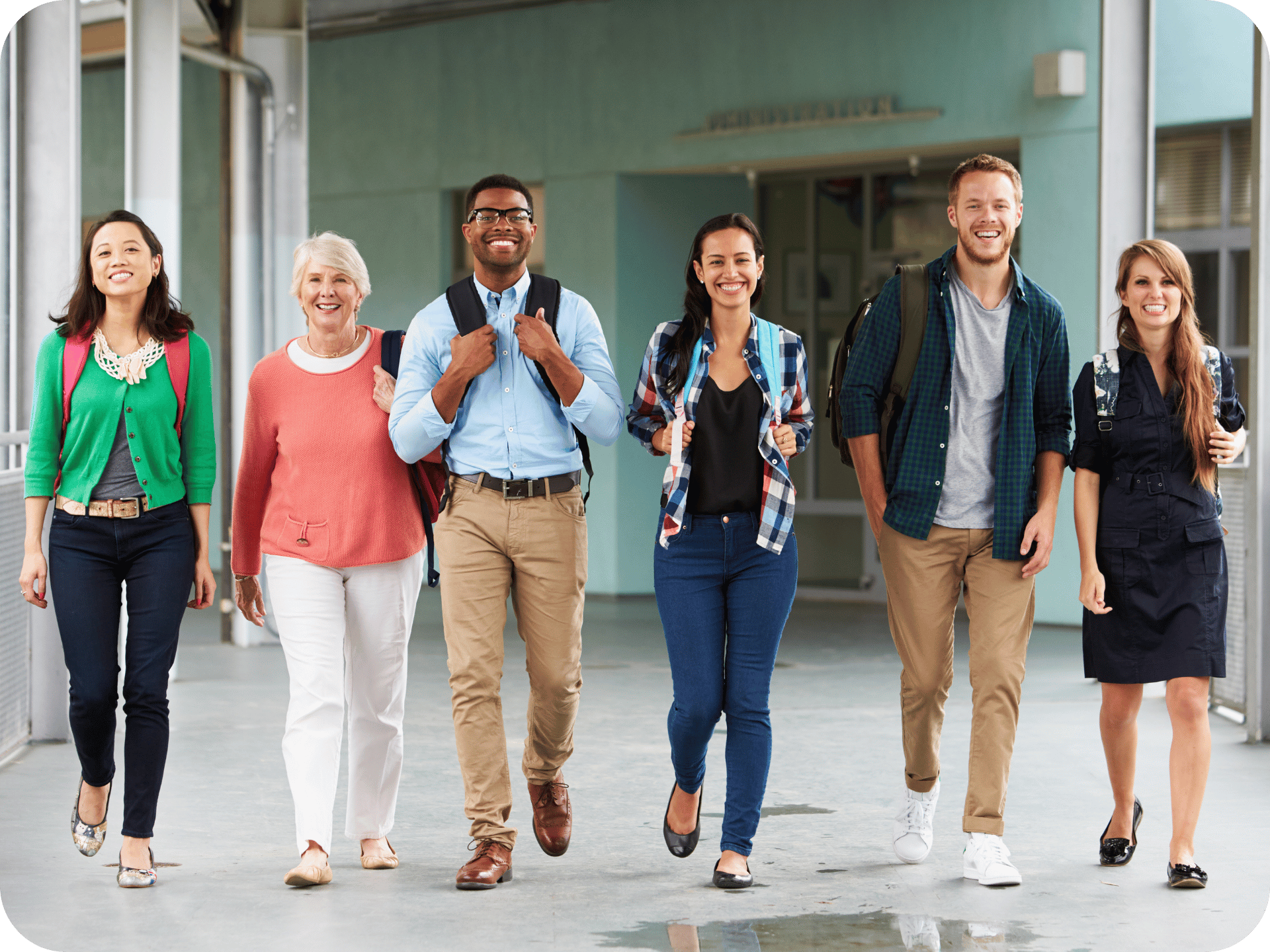 Group of diverse teachers smiling and walking together outside a school
